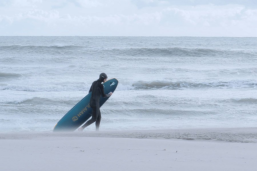 Surfer on the beach in winter