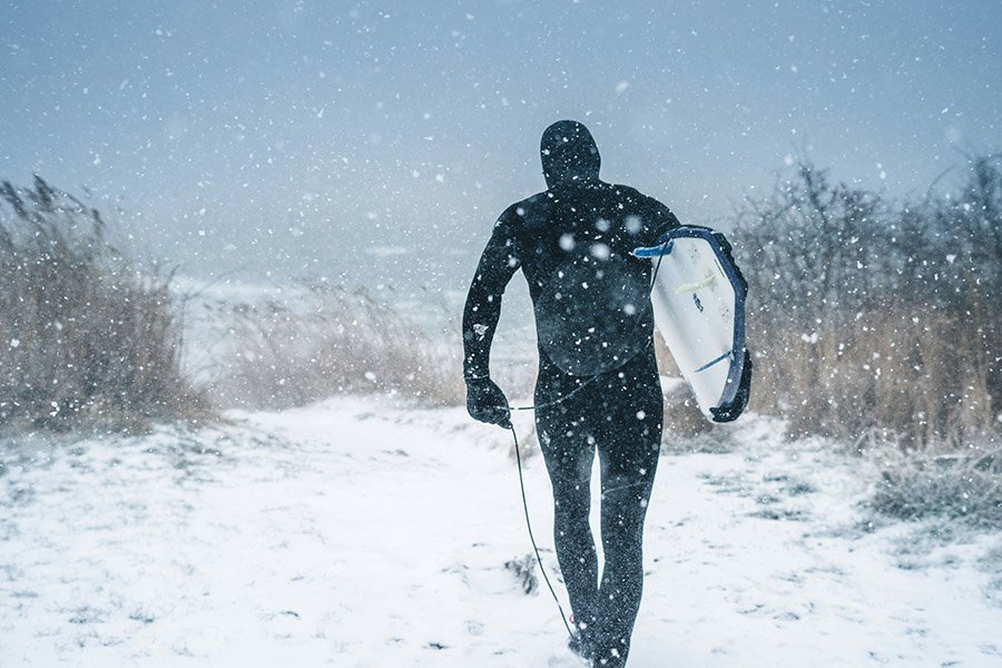 Surfer in snowy winter